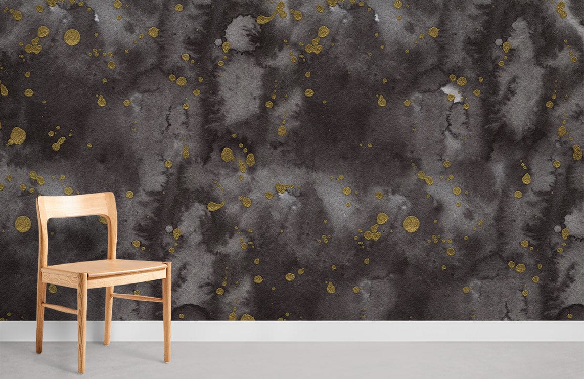 Luxurious abstract black and gold watercolour mural wallpaper with wooden chair and light flooring.