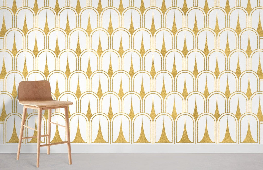 Art Deco gold and white wallpaper with geometric pattern, wooden stool, and grey flooring in modern interior.