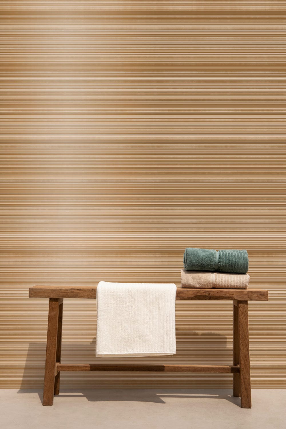 Elegant Metallic Bronze Striped Textured Wallpaper, wooden bench, towels; modern interior design.
