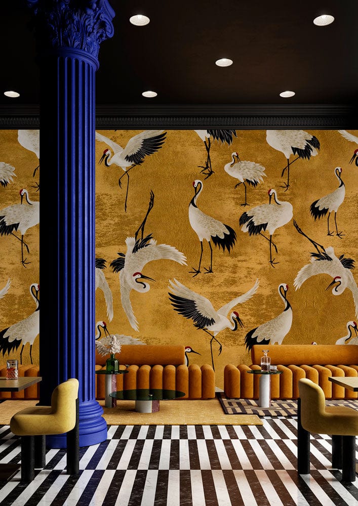 Elegant Golden Crane wallpaper with vintage oriental design, yellow seating, striped flooring, and blue column.
