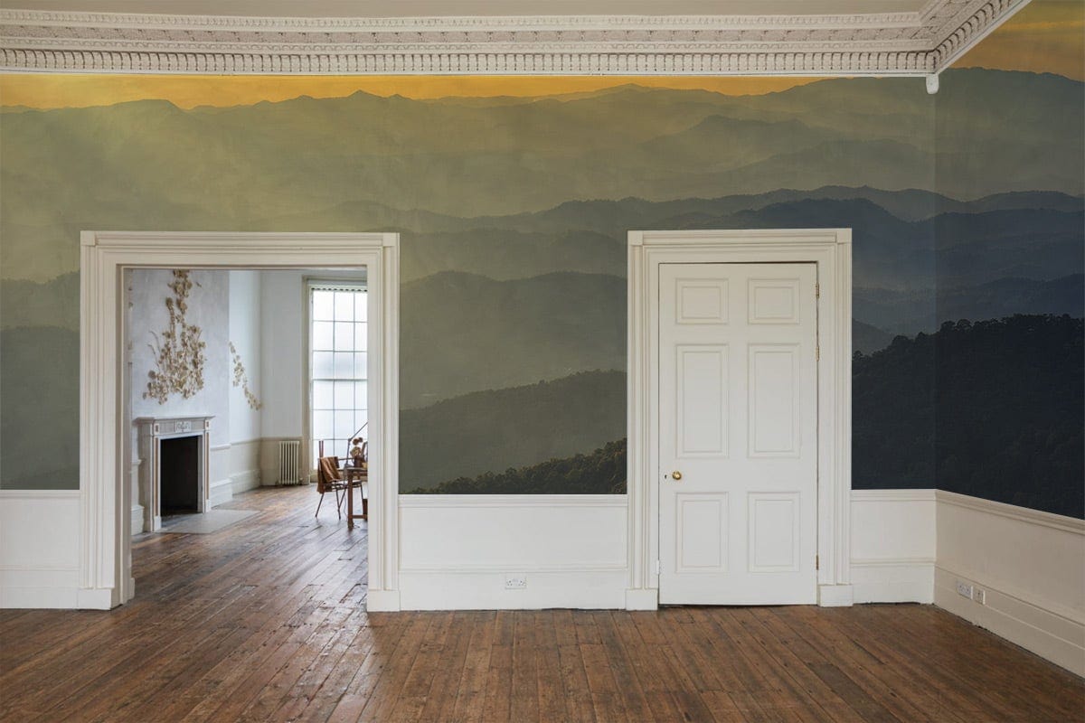 Serene Sunset Mountain wall mural in golden amber, classic white doors, wooden floor, elegant dining room.