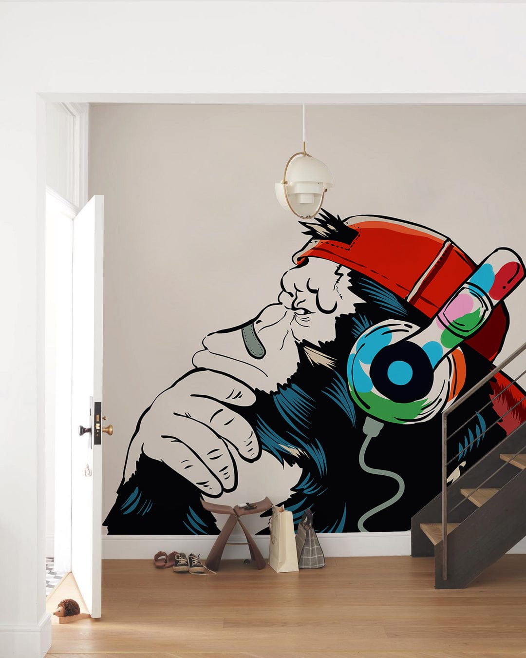 Modern Urban Ape mural in white room featuring wood flooring and modern staircase. Unique street art.