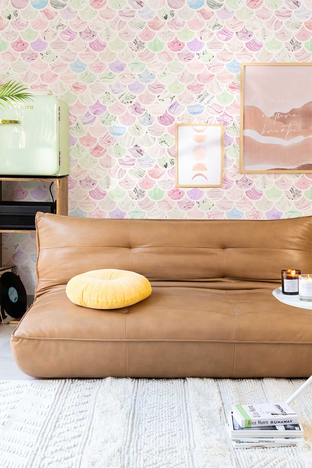 Pastel Scallop Shell wallpaper in living room, brown leather sofa, wooden flooring, colourful coastal decor.