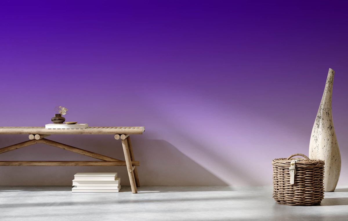 Purple ombre gradient wallpaper in modern decor setting, featuring wicker basket, bench, concrete flooring.
