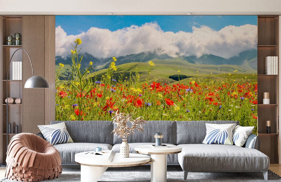 Vibrant Countryside Blossom Mural Wallpaper; grey sofa, round tables, wood shelving, modern living room setting.
