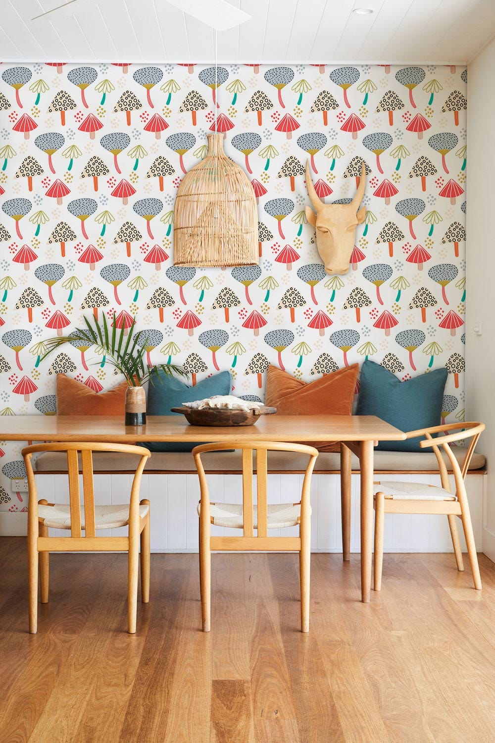 Cosy dining room featuring Vintage Pastel Geometric Trees Pattern Wallpaper, wooden chairs, plush cushions.