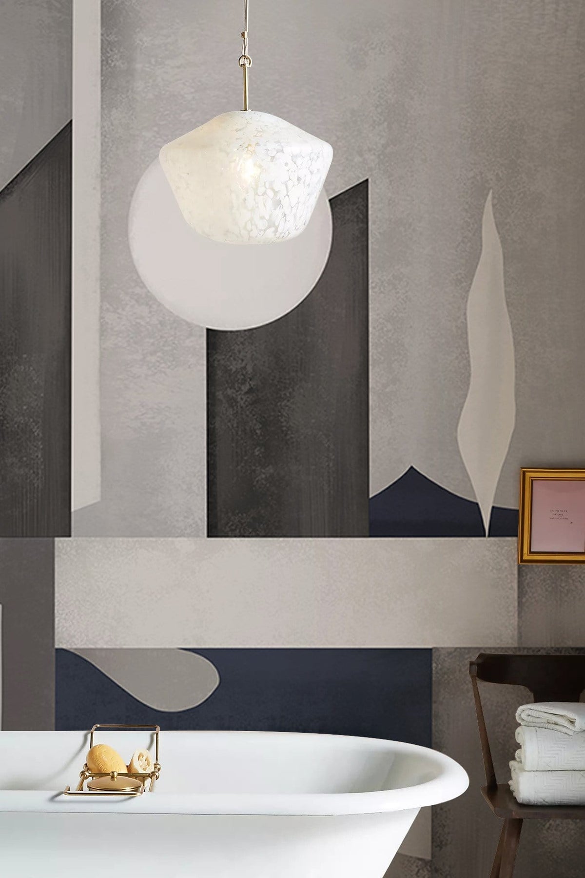 Monochrome geometric mural wallpaper with freestanding bathtub, pendant light, and chair in modern bathroom.