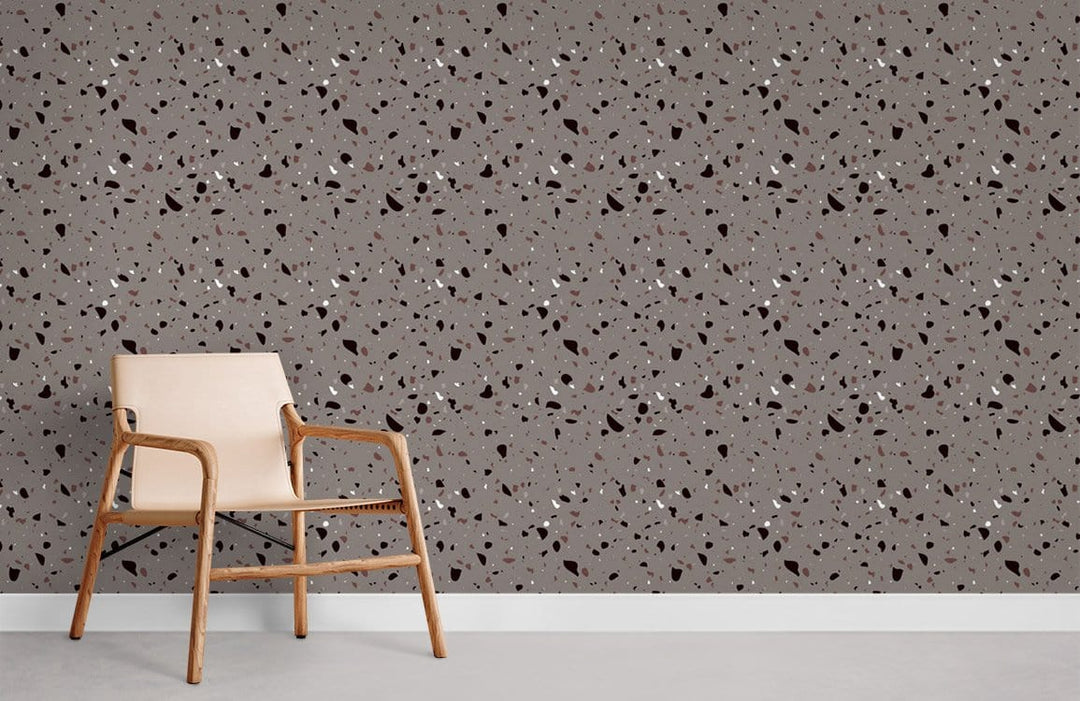 Modern grey terrazzo-style speckled wallpaper with beige chair, chic interior design solution for living room.