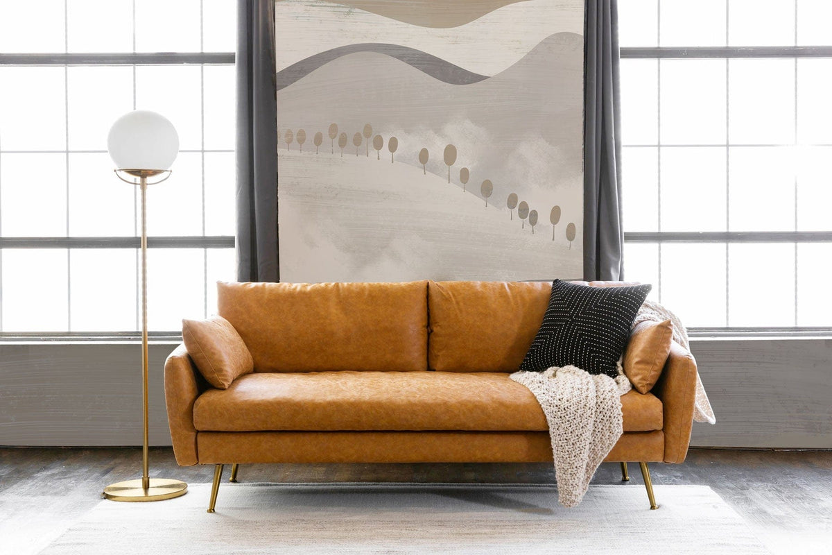 Brown leather sofa, abstract mountain mural wallpaper, laminate flooring, modern lamp in living room setting.