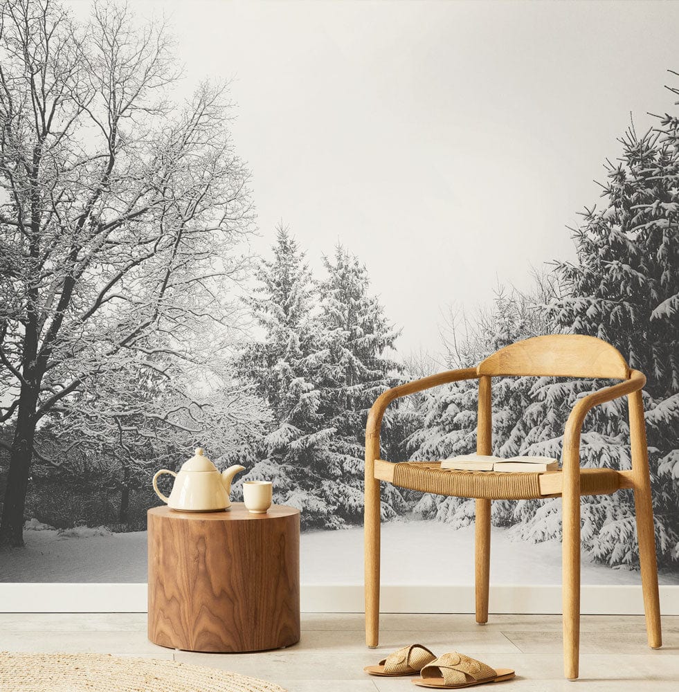 Winter Wonderland Forest Mural Wallpaper with wooden chair, round side table, and minimalist flooring.