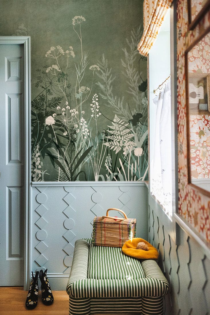 Botanical Forest Green Floral Mural Wallpaper, elegant design, hallway setting, striped bench seating, window.