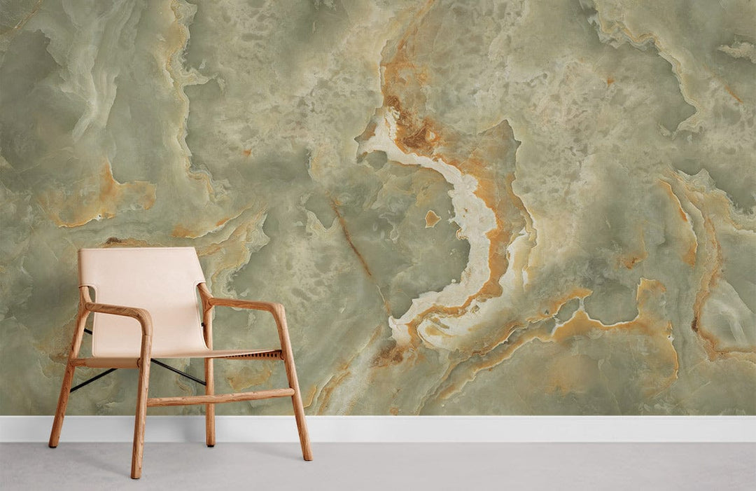 Elegant interiors with abstract green marble effect wallpaper featuring gold accents, beige armchair, grey flooring.