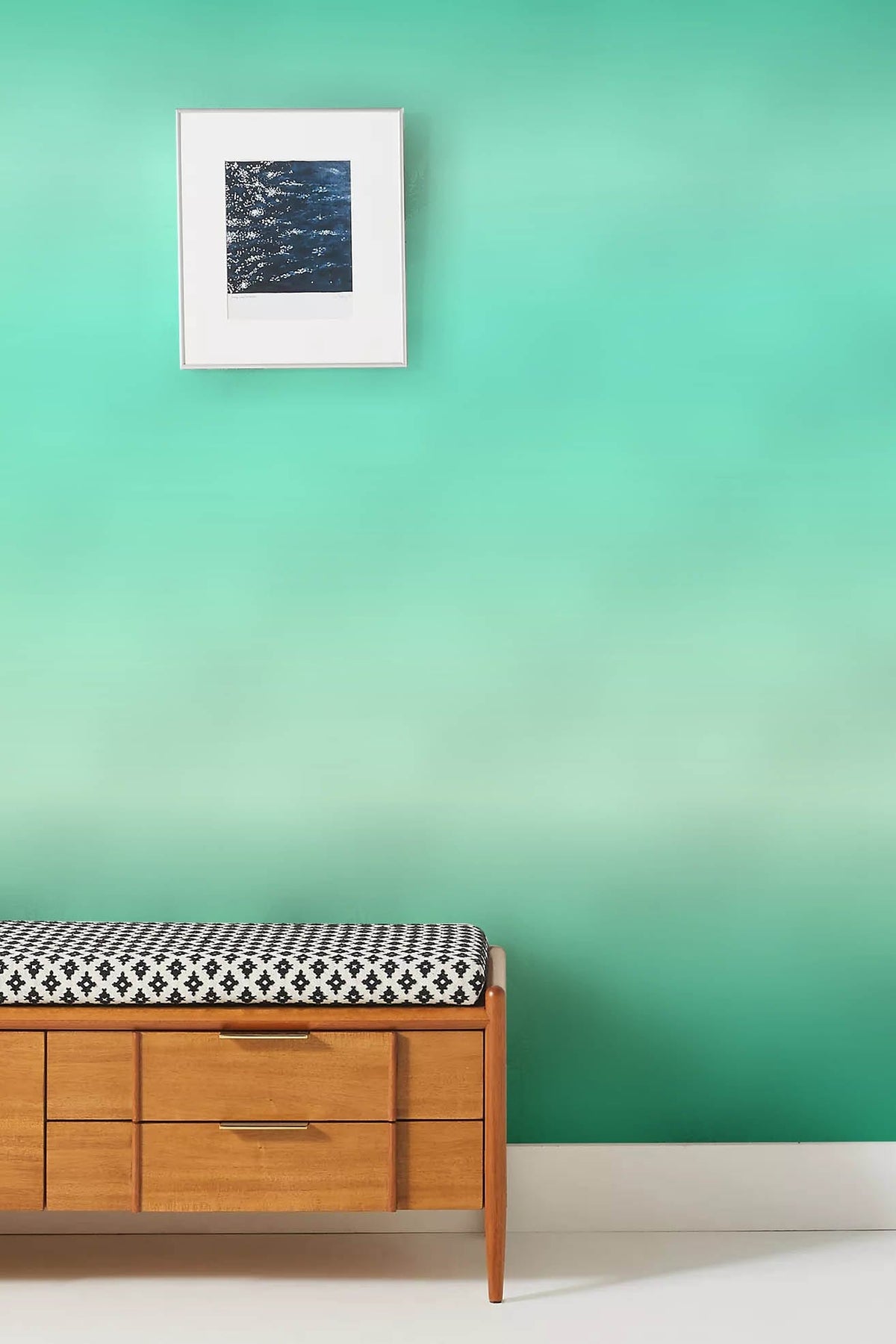 Serene Aqua Wallpaper in living room with wooden bench and abstract artwork on mint gradient wall.