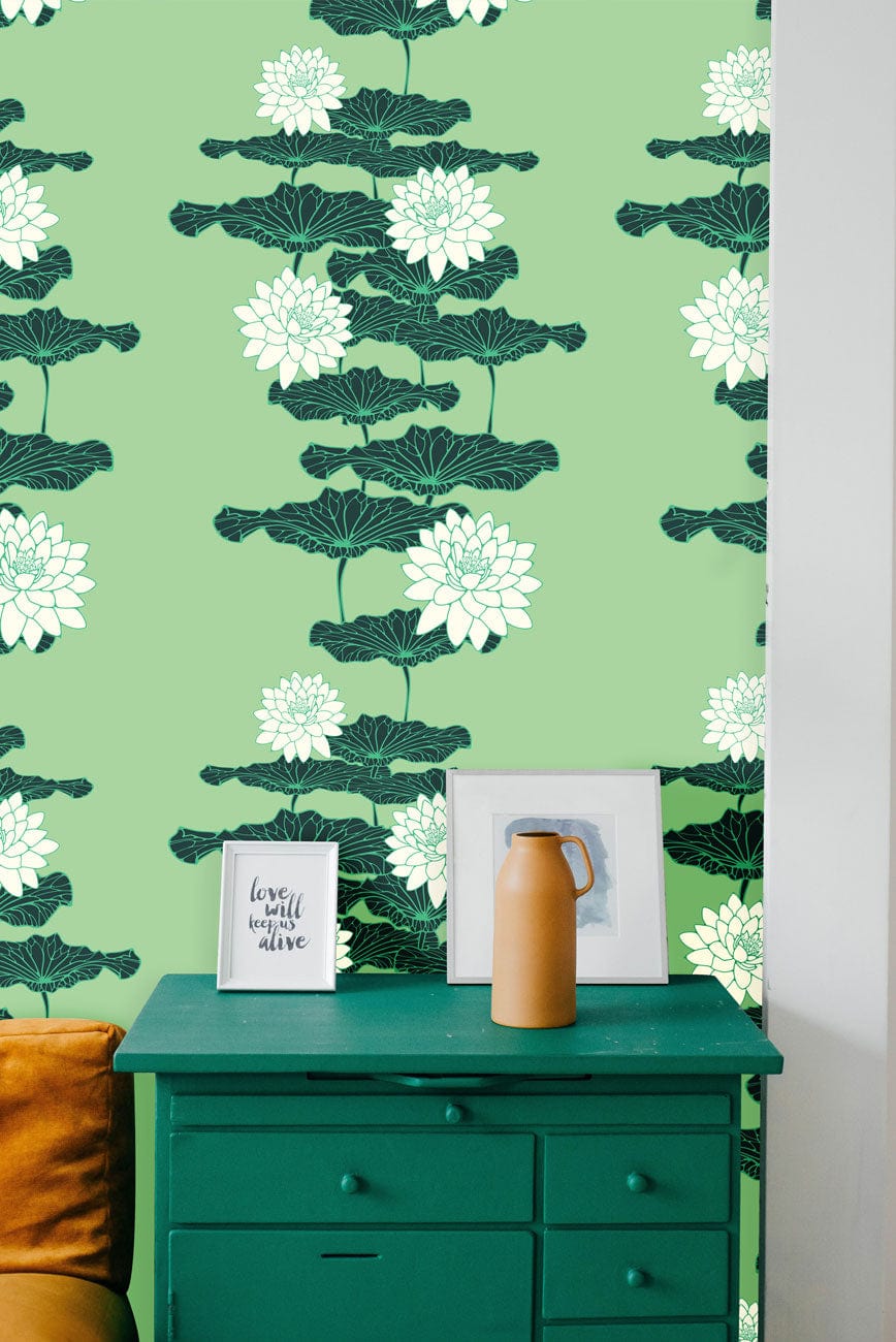 Green floral wallpaper, nature-inspired pattern with orange sofa, green dresser, wall art in elegant interior.