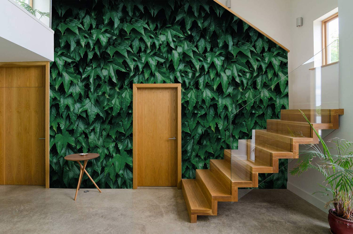 Vibrant ivy wall mural in modern hallway with wooden stairs, light grey flooring, and minimalist decor.