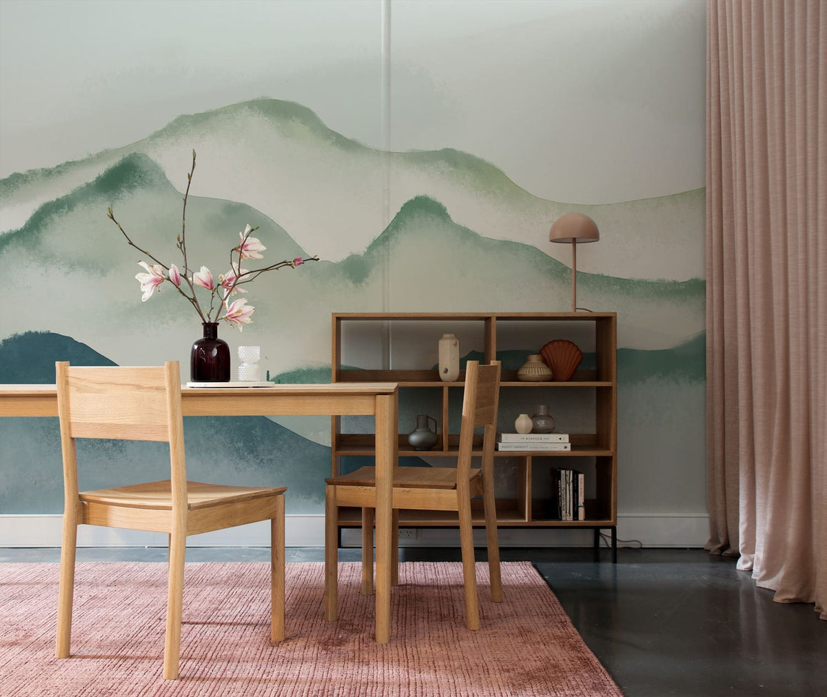 Elegant watercolour landscape mural wallpaper in dining room, wooden furniture, pink rug, serene mountain art.