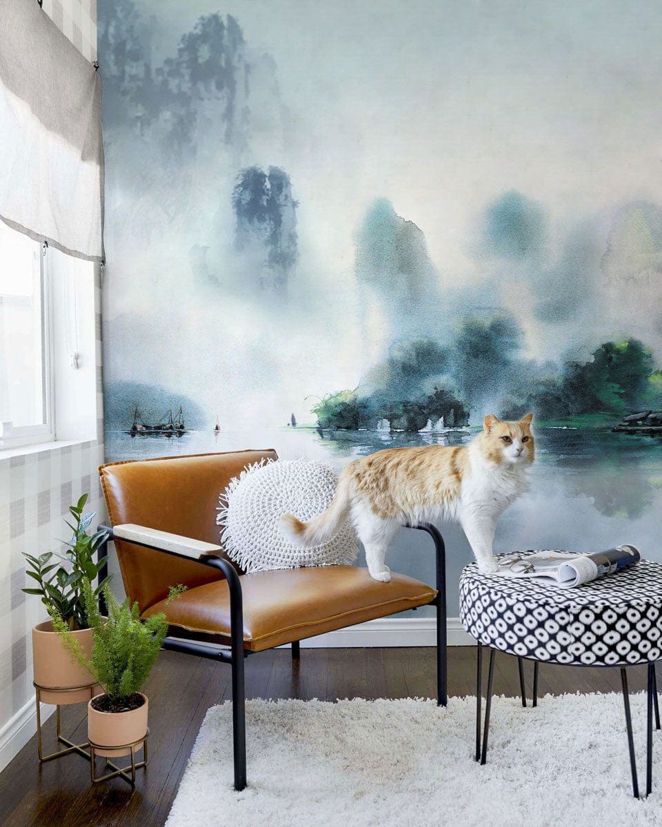Serene Misty Mountain Watercolour Mural in living room with brown leather chair, patterned round table, cat.