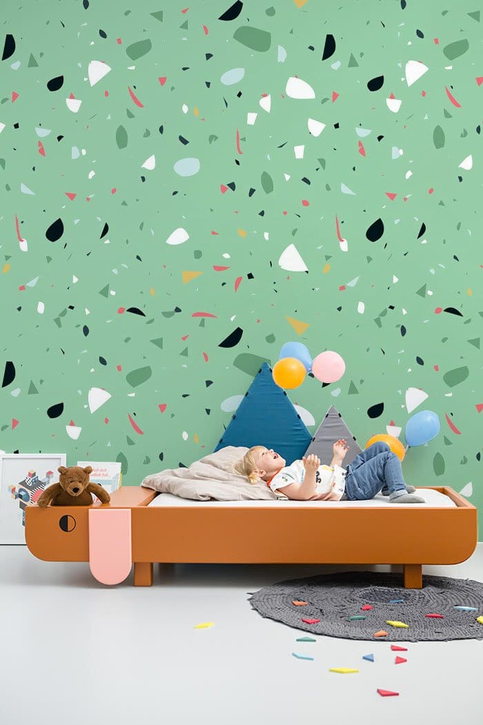 Mint green speckled terrazzo wallpaper in modern kids' room with playful bed, wooden furniture, cosy ambience.