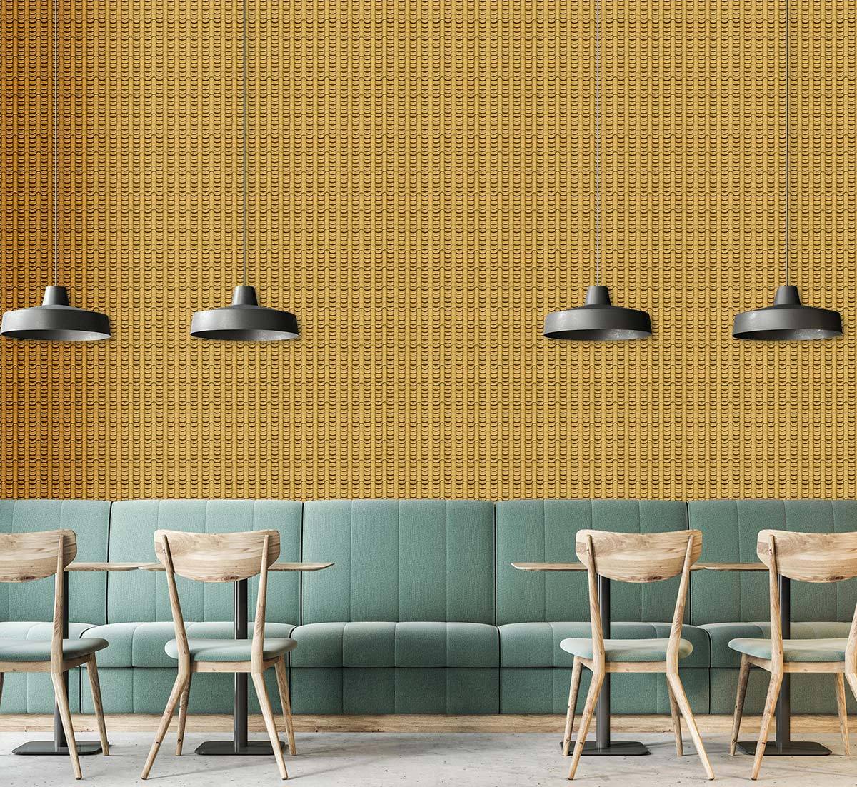 Vintage mustard yellow geometric wallpaper, teal sofa, wooden chairs, pendant lights, and concrete flooring.