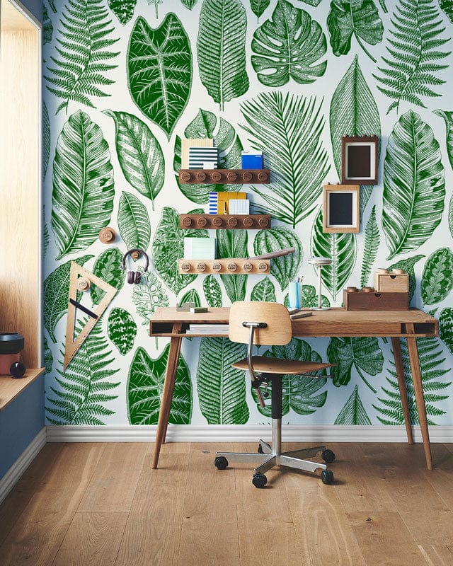 Tropical green leaf wallpaper, lush botanical jungle decor, stylish desk, wooden flooring, home office setting.