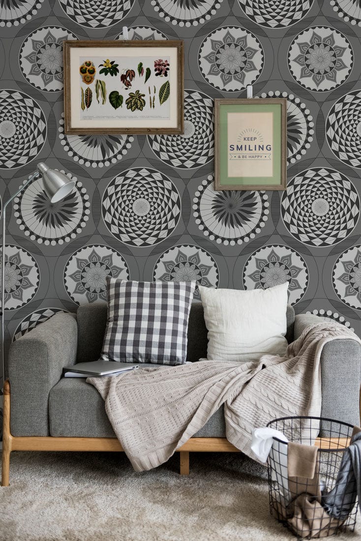 Monochrome geometric circle wallpaper, grey sofa, checkered cushions, beige throw, framed wall art, carpet flooring.