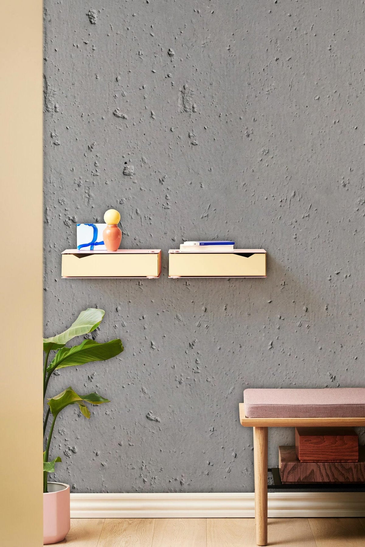 Modern grey concrete texture wallpaper in room with wooden bench and floating shelves, industrial chic decor.