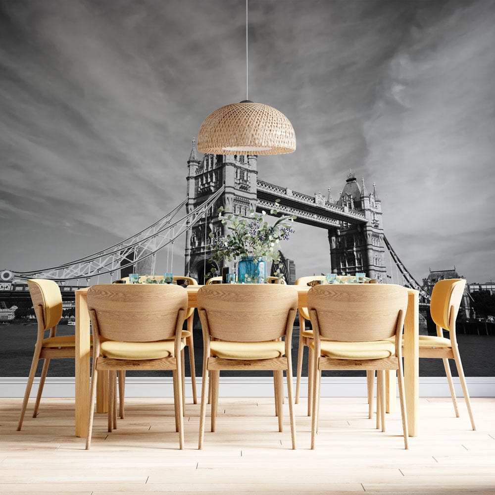 Black and White Tower Bridge mural in dining room with wooden chairs, pendant light, wood flooring.