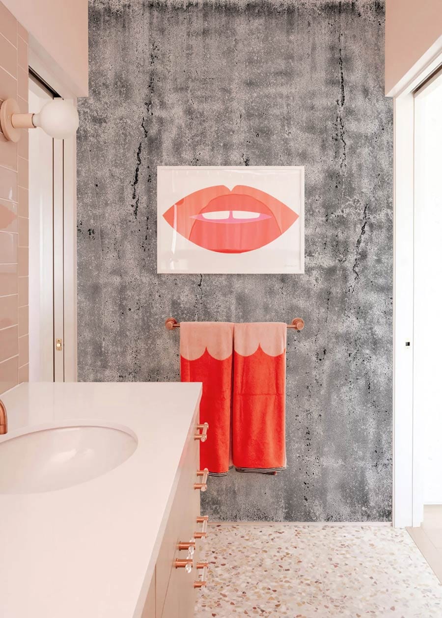 Bathroom with Industrial Grey Concrete Texture Wallpaper, terrazzo flooring, modern art, and coral accents.