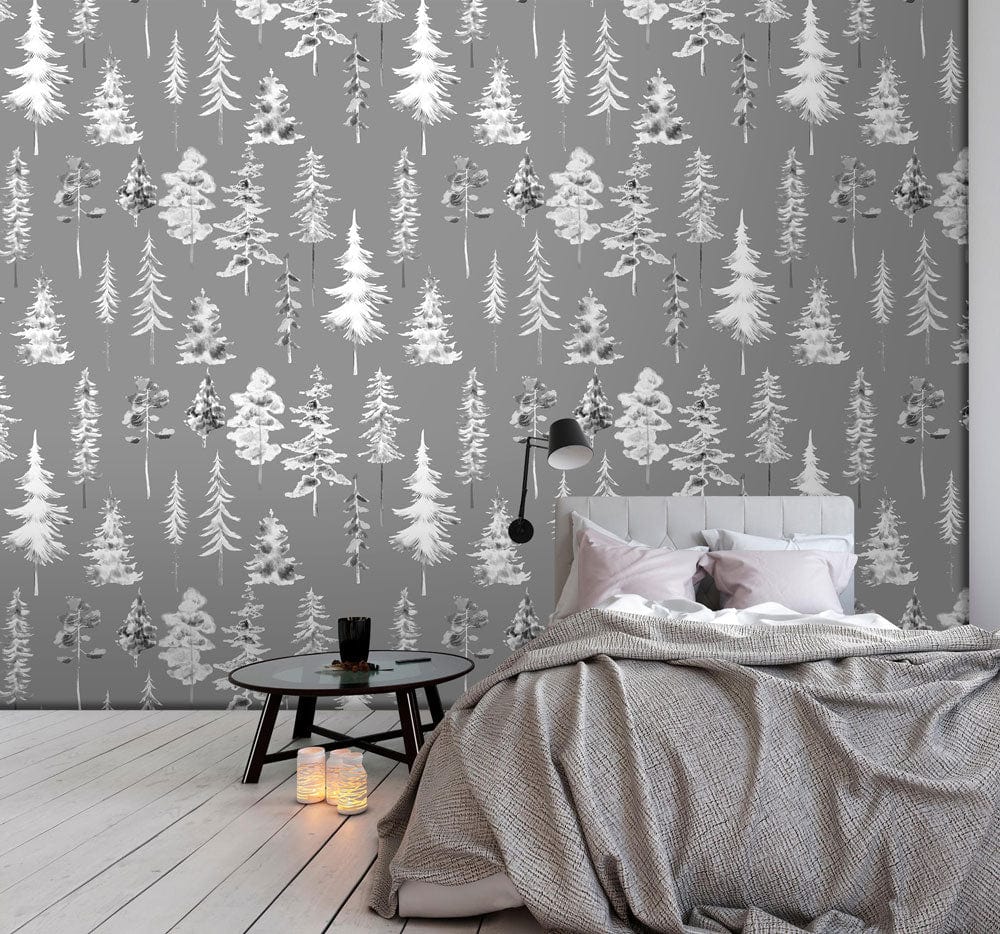 Grey woodland forest wallpaper in modern bedroom with plush bed, round black side table, and wood flooring.