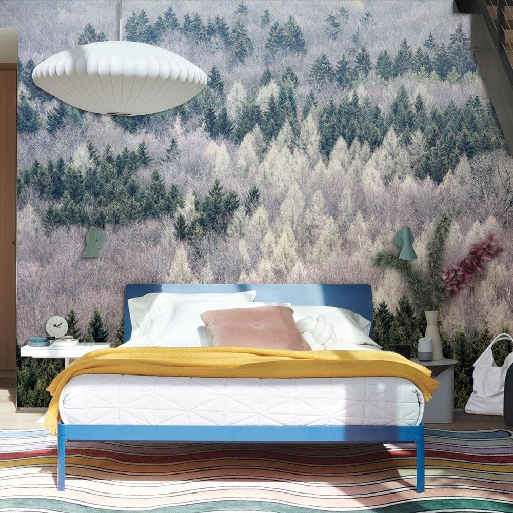 Tranquil misty forest mural wallpaper in bedroom with modern pendant light and colourful striped rug.