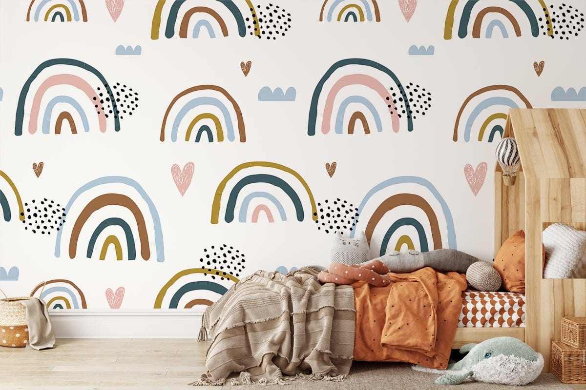 Children's room with pastel rainbow heart wallpaper, wood bed, cosy cushions, and light wood flooring.