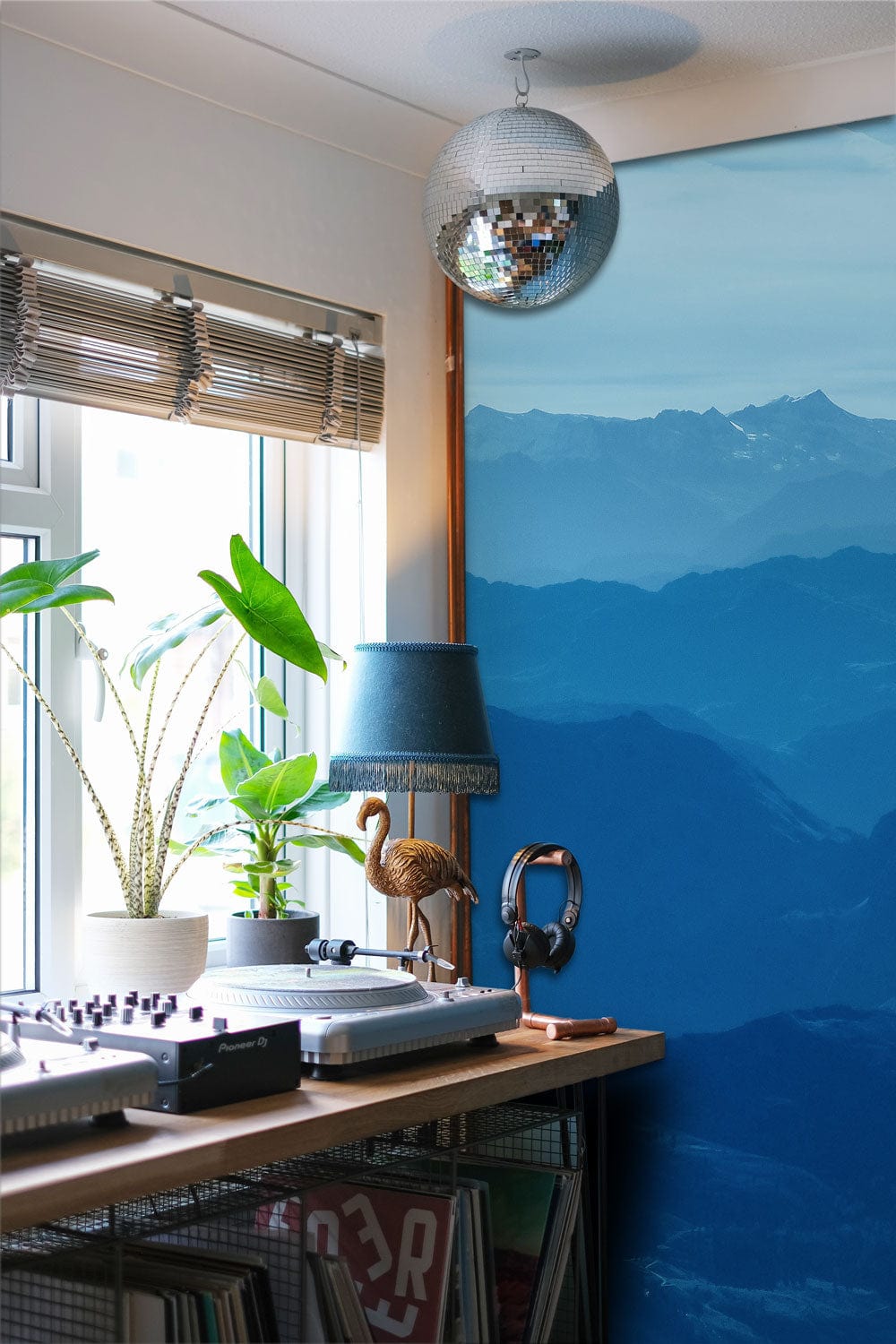 Serene Blue Mountain Mural Wallpaper in home office with wooden desk, large window, and blue lamp.
