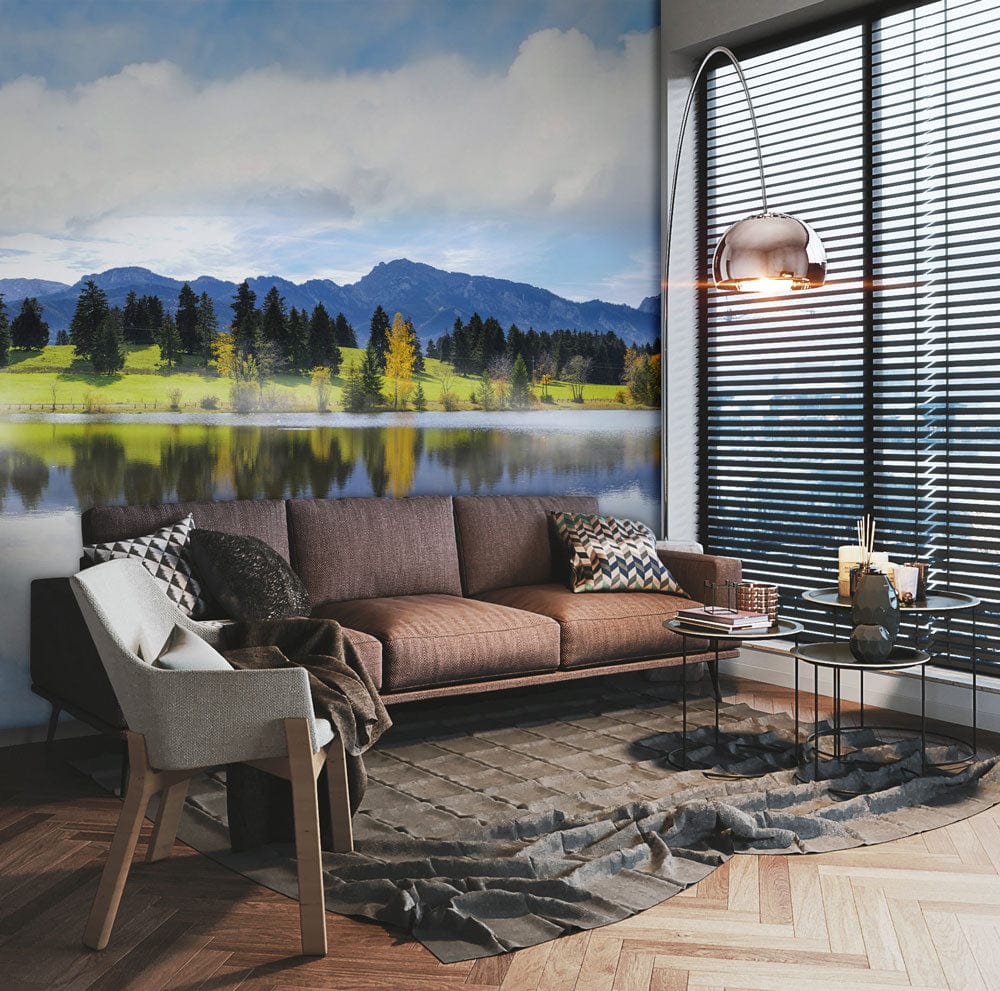 Tranquil Mountain Lake mural wallpaper in modern living room with brown leather sofa, grey armchair, lamp.