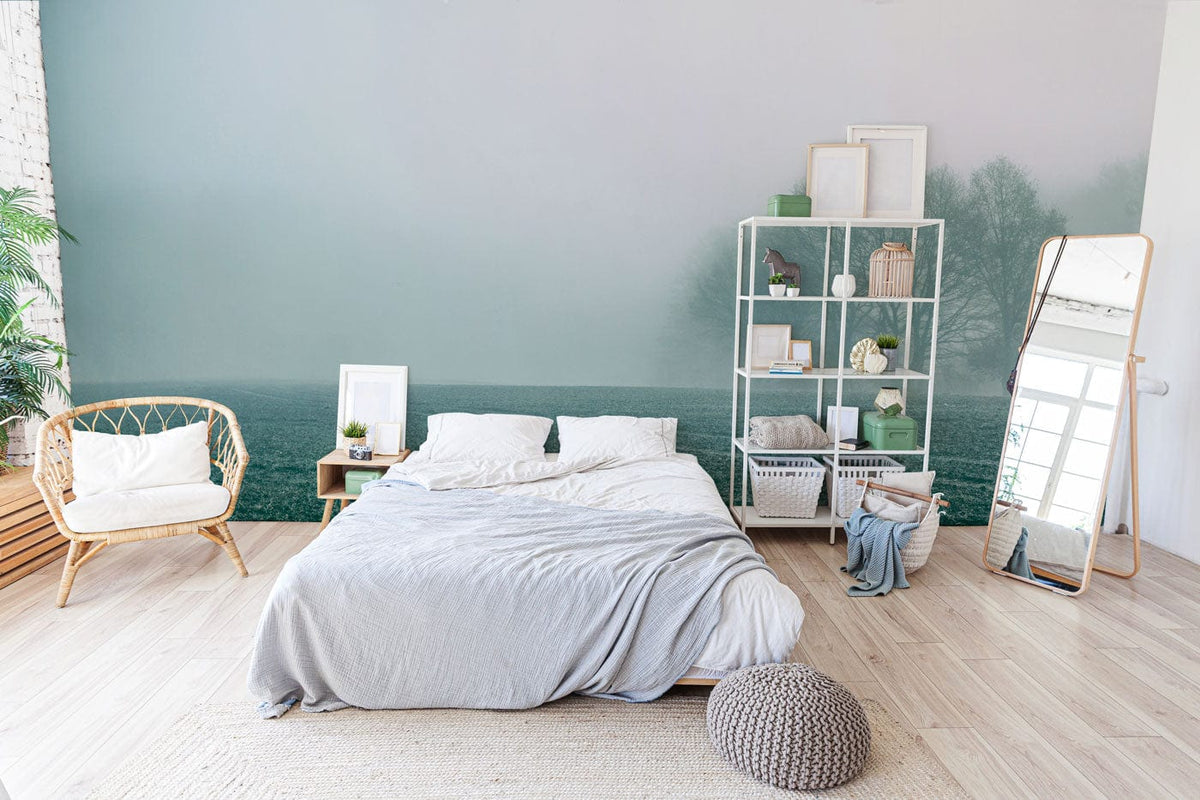 Misty Morning Landscape Mural Wallpaper; serene bedroom with rattan chair, wooden flooring, shelving unit, mirror.