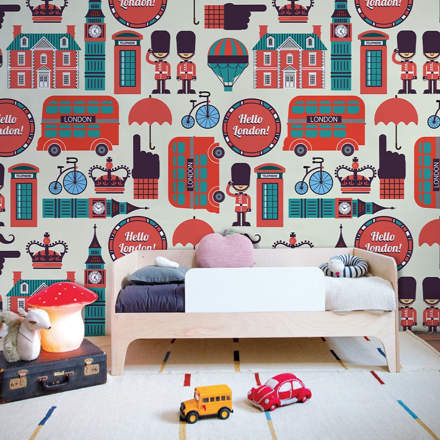 Retro London Icons wallpaper in vintage red, blue; cream nursery, wooden bed, toys, geometric rug.