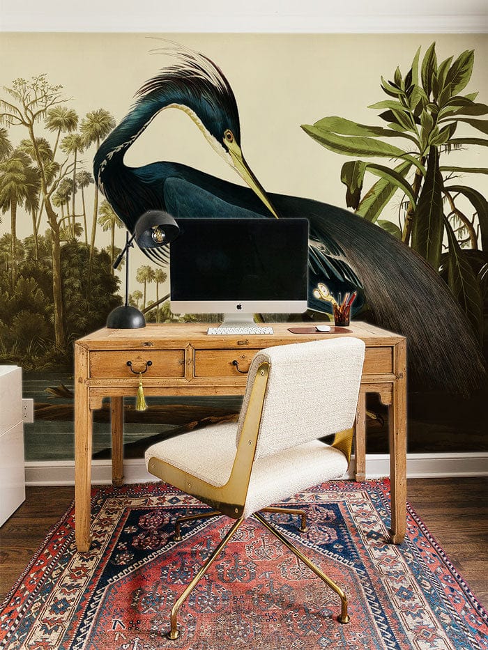 Elegant Blue Heron mural wallpaper in study with wooden desk, white chair, and patterned rug.