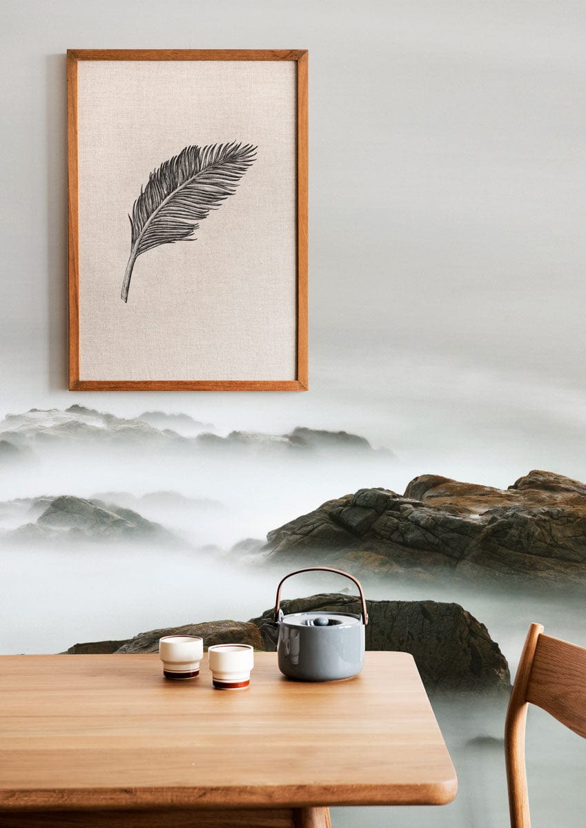 Ethereal wallpaper Décor with coastal rocks, wooden table, framed artwork, and misty seascape theme.