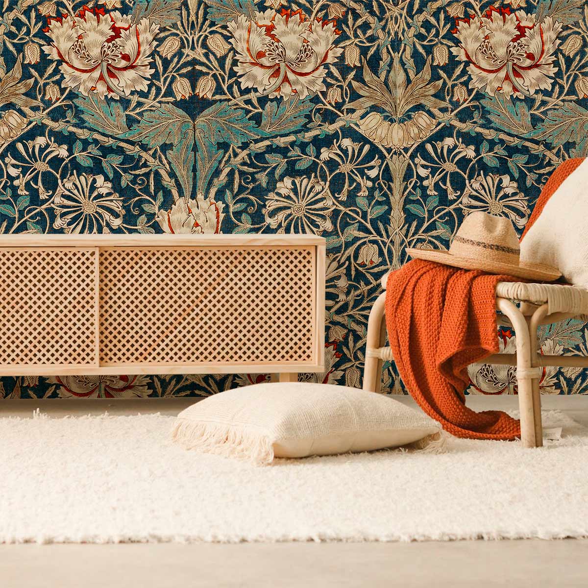 Luxurious vintage floral tapestry wallpaper in teal tones, wicker cabinet, cream rug in living room.