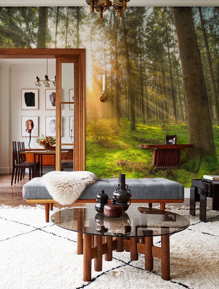 Forest Serenity Sunlit Green Woodland Mural adorns living room with grey sofa, modern table, patterned rug.
