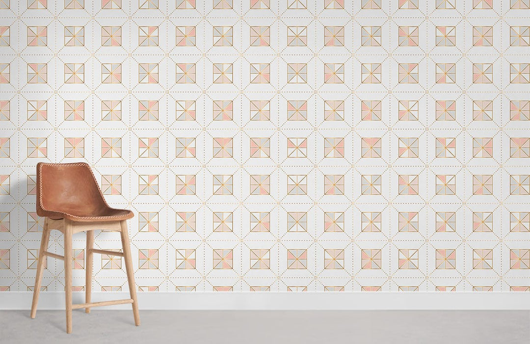 Geometric soft pink and gold wallpaper with brown leather chair on grey flooring for modern interiors.