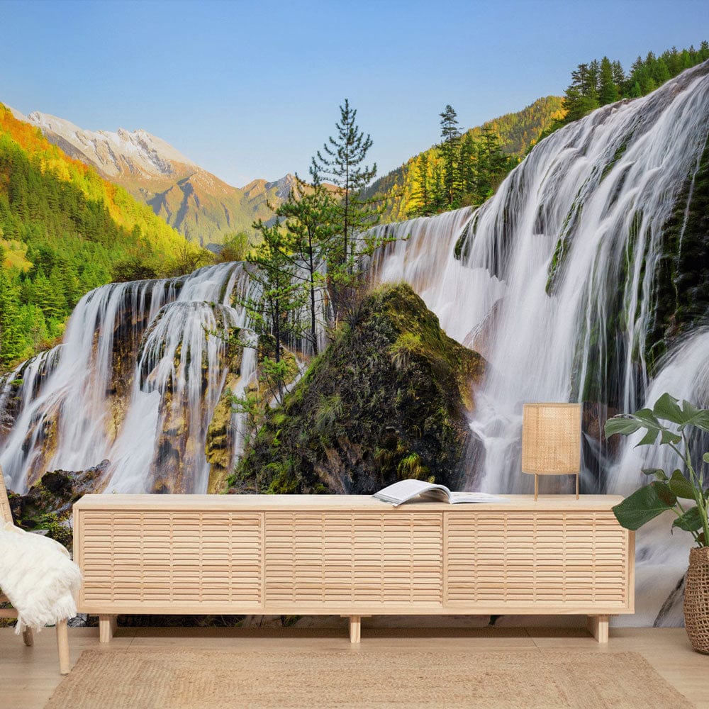 Natural waterfall mural wallpaper with lush greenery, wooden console, and light rug in modern lounge.