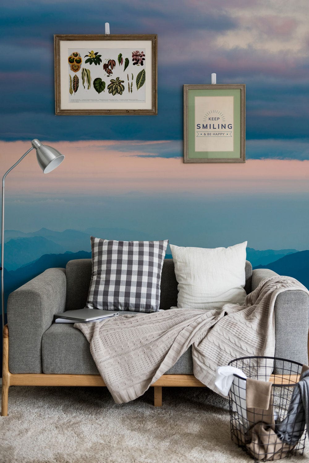 Grey sofa with Serene Mountain Vista Wallpaper, soft blue tones, framed wall art, modern lamp, cosy rug.