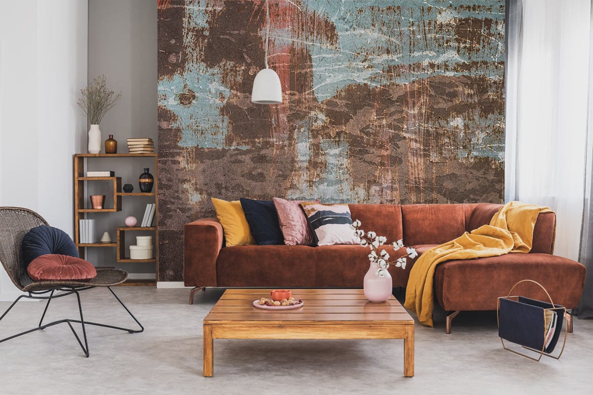Rustic industrial wallpaper, earthy tones; vintage decor with brown sofa, wooden coffee table, modern chair.