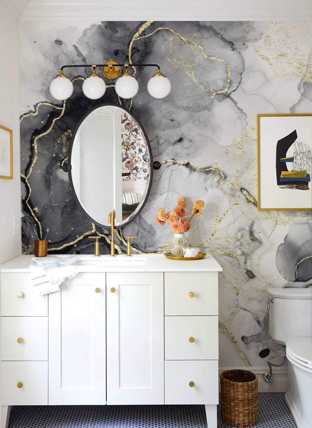Luxurious marble effect mural wallpaper in bathroom with gold fixtures, white vanity, and oval mirror.