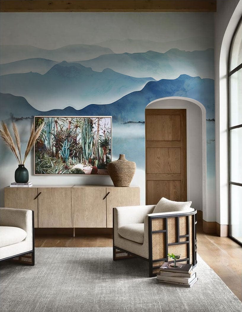 Tranquil Blue Misty Mountain mural wallpaper in living room with beige armchairs, wooden flooring, archway.