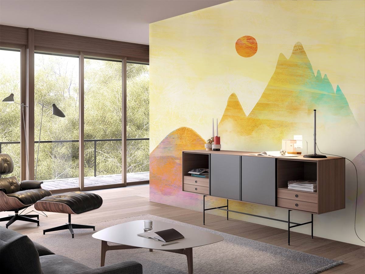 Sunset pastel mountains mural with yellow tones, in modern living room with brown armchair and console.