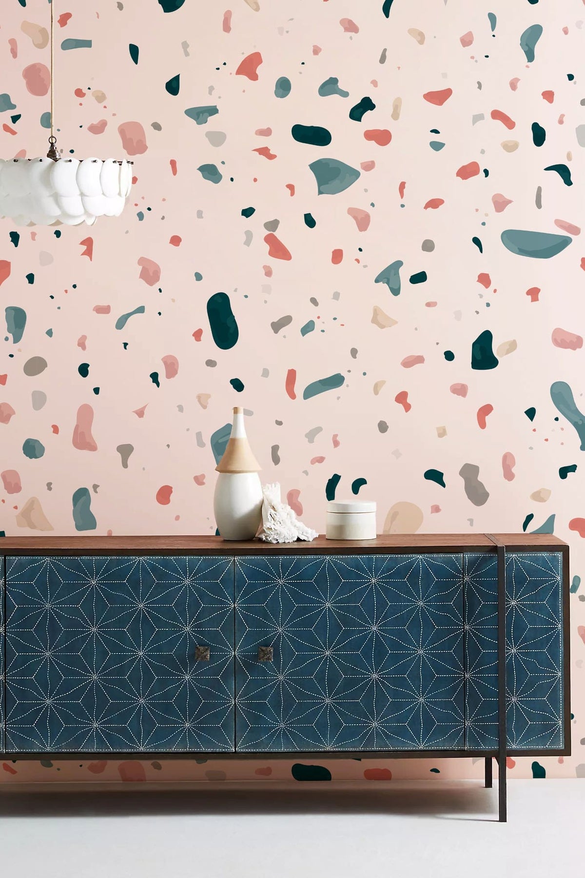 Modern multicolour terrazzo wallpaper with abstract design; features a decorative sideboard and pendant light.