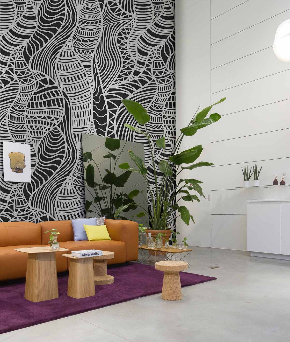 Abstract Monochrome Geometric Pattern Wallpaper in modern living room with orange sofa and purple rug.