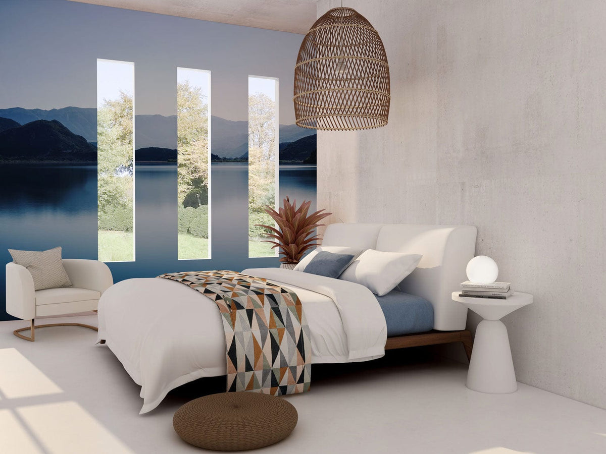 Peaceful lake and mountain mural wallpaper in serene bedroom with white walls, modern bed, and chair.