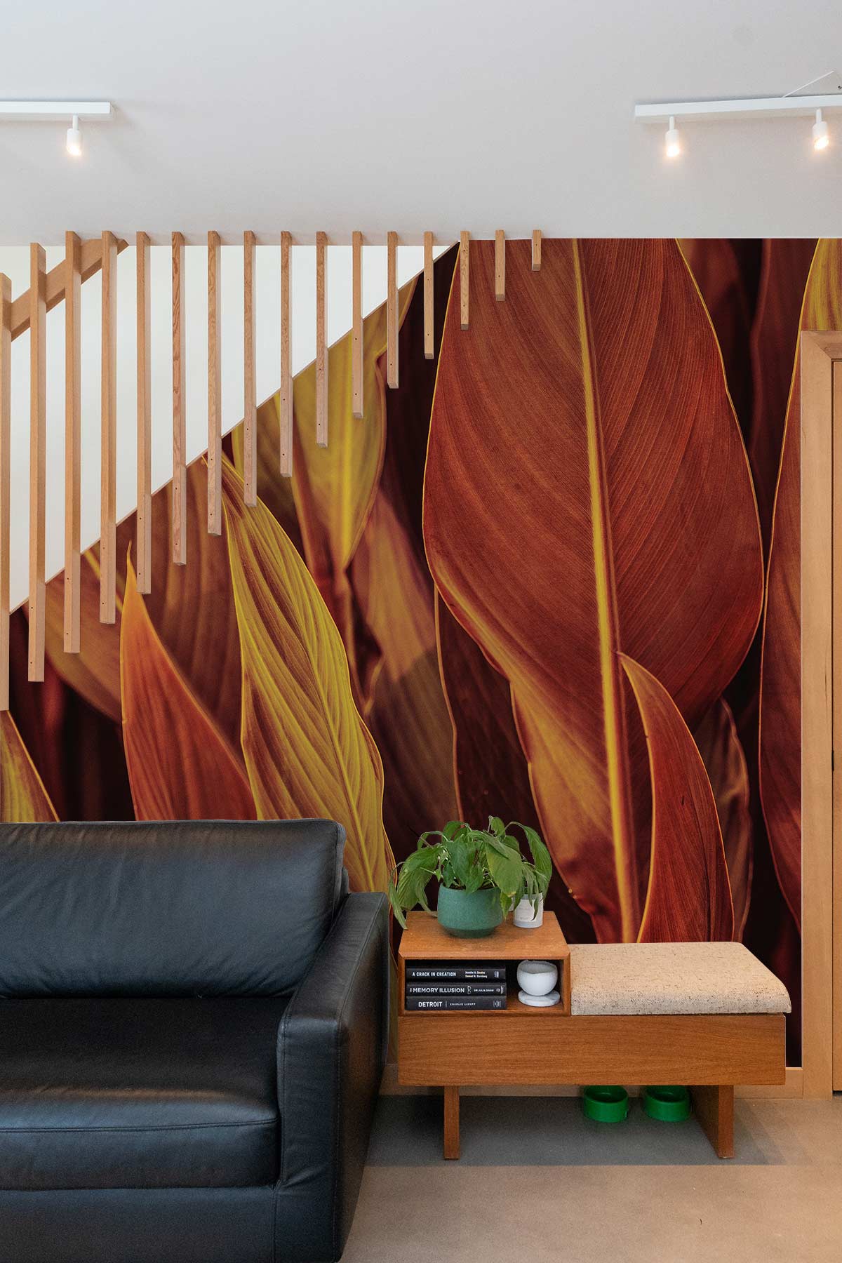 Rich Autumn Leaves Wallpaper with black sofa, wooden feature wall, minimalist decor, modern living room.